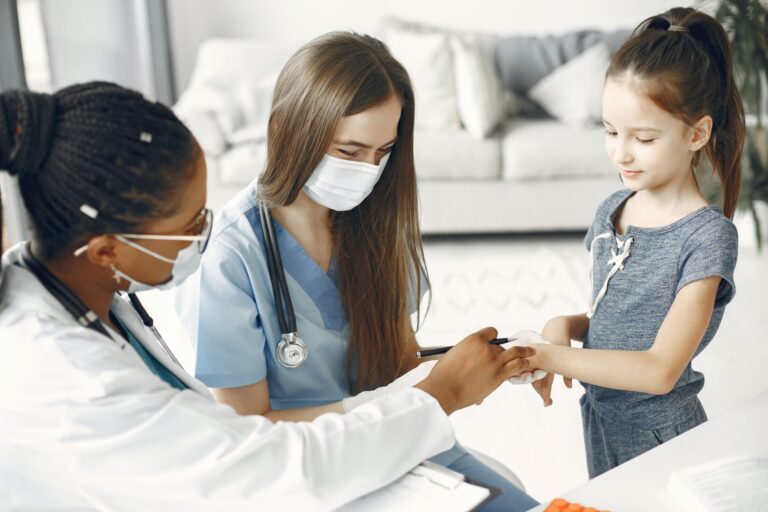 Doctor and nurse taking child's vitals
